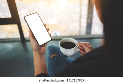 Mockup Image Of A Woman Holding Mobile Phone With Blank Screen While Drinking Coffee 