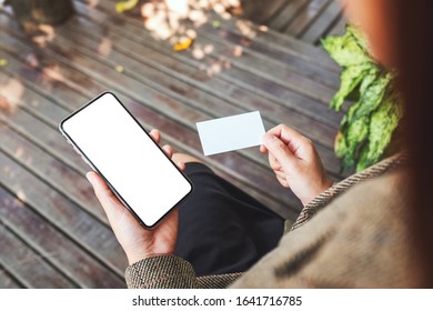 Mockup Image Of A Woman Holding White Mobile Phone With Blank Desktop Screen And A White Empty Business Card