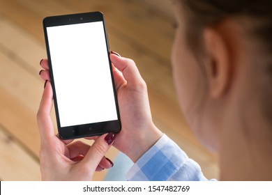 Mockup Image: Woman Looking At Black Smartphone With White Blank Screen. Close Up View Of Woman Hands With Smart Phone Mobile Device. Mock Up, Copyspace, Template And Technology Concept