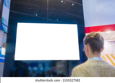 Mockup Image: Woman Looking At Blank Large White Interactive Wall Display At Modern Technology Exhibition, Museum, Trade Show. Mock Up, Isolated, White Screen, Copyspace, Template, Education Concept