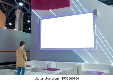 Mockup Image: Woman Looking At Blank Large White Interactive Wall Display At Modern Technology Exhibition, Museum, Trade Show. Mock Up, White Screen, Copyspace, Template, Education Concept