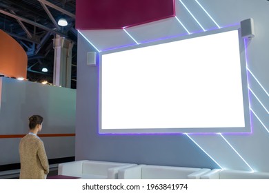 Mockup Image: Woman Looking At Blank Large White Interactive Wall Display At Modern Technology Exhibition, Museum, Trade Show. Mock Up, White Screen, Copyspace, Template, Education Concept