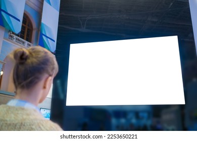 Mockup image: woman looking at blank large white interactive wall display at modern technology exhibition, museum, trade show. Mock up, isolated, white screen, copyspace, template, education concept - Shutterstock ID 2253650221