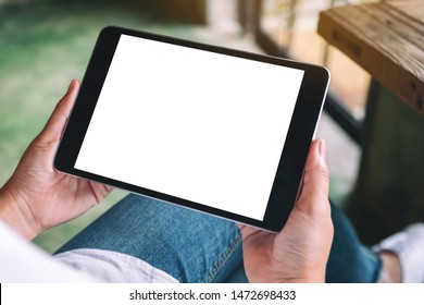 Mockup Image Of A Woman Sitting And Holding Black Tablet Pc With Blank White Desktop Screen 