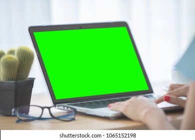 Mockup Image Of A Woman Using Laptop With Blank Green Screen.