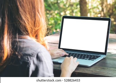 Mockup Image Of A Woman Using Laptop With Blank White Screen On Vintage Wooden Table In Nature Outdoor Park