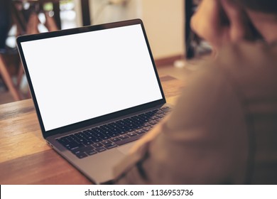 Mockup Image Of A Woman Using And Looking At Laptop With Blank White Screen On Table In Cafe