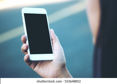 Mockup Image Of A Woman Using Smart Phone With Blank Black Screen At Outdoor 