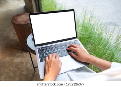 Mockup Image Of A Woman Using And Typing On Laptop Computer With Blank White Desktop Screen In Cafe