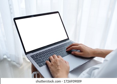 Mockup Image Of A Woman Working And Typing On Laptop Computer With Blank Screen While Sitting In A Bedroom At Home