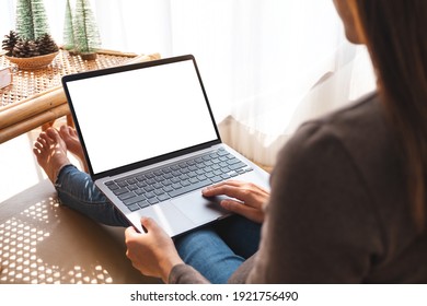 Mockup Image Of A Woman Working And Typing On Laptop Computer With Blank White Screen At Home