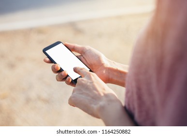 Mockup image of woman's hand holding and using white mobile phone at outdoor with copy space,blank screen for text.concept for business,people communication,technology electronic device. modern life s - Shutterstock ID 1164250882