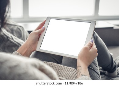 Mockup image of woman's hand holding white tablet pc with blank white screen at home