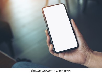 Mockup image of a woman's hand holding black mobile phone with blank desktop screen  - Shutterstock ID 1356488909