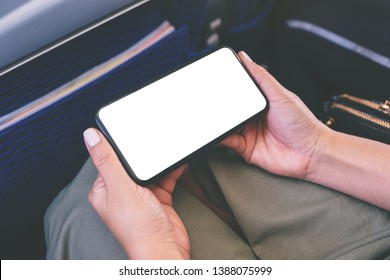 Mockup Image Of Woman's Hand Holding A Black Smart Phone With Blank Desktop Screen In Cabin