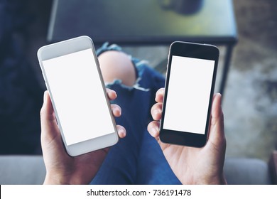 Mockup image of a woman's hands holding two mobile phones with blank white screen in modern cafe