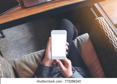 Mockup Image Of A Woman's Hands Holding White Mobile Phone With Blank White Screen On Thigh 