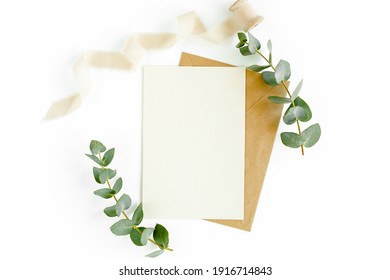 Mockup Invitation, Blank Greeting Card And Green Leaves Eucalyptus. Flat Lay, Top View.