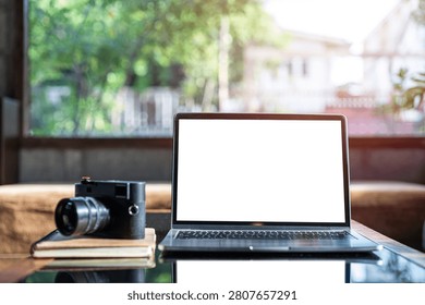 Mockup of laptop computer with empty screen of coffee, modern smartphone, wireless earbuds, notebook, a pen, classic black rangefinder camera morning sunlight.