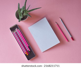 Mockup Of Light Gray Paper Page For Sketch, Artwork Or Logo Design. Pink Desk Work With Grey Card, Pink Pencils, Pencil Box And Green Cactus Plant. Blank Paper Sheet, A5 Size. Pink Aesthetic. School.