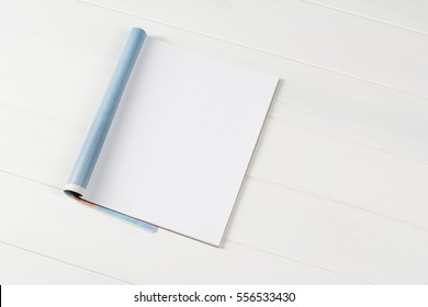 Mock-up magazine or catalog on wooden table. Blank page or notepad on wood background. Blank page or notepad for mockups or simulations. - Shutterstock ID 556533430