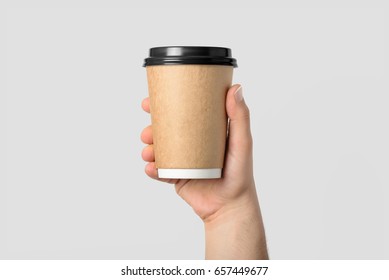 Mockup Of Male Hand Holding A Coffee Paper Cup Isolated On Light Grey Background. 