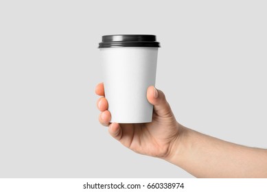 Mockup Of Male Hand Holding A Coffee Paper Cup Isolated On Light Grey Background. 