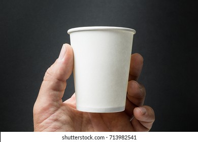 Mockup Of Male Hand Holding A Coffee, Tea Or Juice Paper Cup Isolated On Black Background.