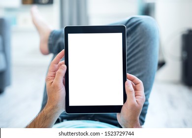Mockup of a Man Using Tablet PC While Lying on a Floor. Clipping path included.