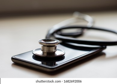 Mockup medical stethoscope and  mobile smart phone isolated on wood table background. Meditech, online medical, emr, telehealth concept. 