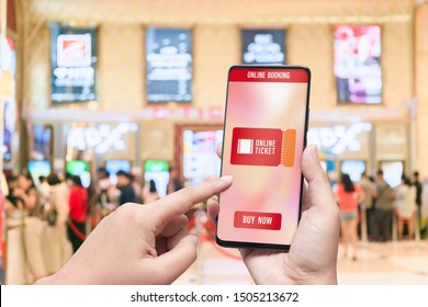 Mockup Mobile Phone Hand Using Smartphone To Buy Cinema Tickets With Blurred Image Of Ticket Sales Counter At Movie Theater With Graphic Icon, Online Booking And Payment Concept