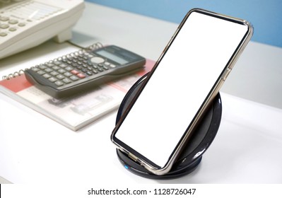 Mockup Of Mobile Phone With Wireless Charger And Office Equipment,Free Space For Textures.