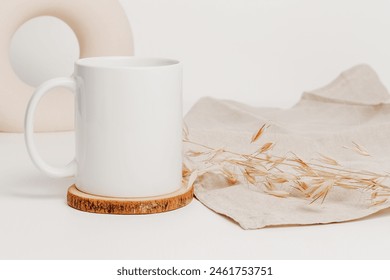 Mockup mug on wooden cup coaster with linen cloth and vase at the background. Mockup mug for logo, branding, print, gift and design