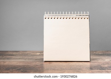 Mockup Notepad. Blank Spiral Bound Notepad Mockup With On Light Grey Background And Wooden Table. Template For Placing Your Design.