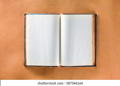 Mockup Of Opened Vintage Book With Shabby Cover And Blank Pages At Brown Leather Skin Background.