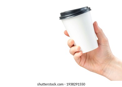 Mockup Of Paper Coffee Cup In Hand Isolated On White Background. Male Hand Holds A Disposable Mug With A Black Lid. Advertising Latte Or Tea.