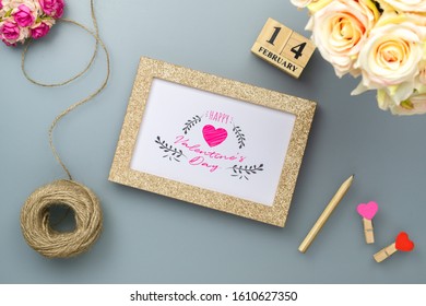 Mockup Photo Frame For Valentines Day Concept. Top View Of Mock Up Photoframe With Rose Flowers, Craft Roses And Handy Craft On Grey Home Office Desk Table Background.