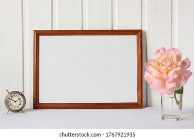 Mockup, Scene Creator With An Empty Wooden Frame On The Table And A Rose Flower. Space For Your Text Or Image.