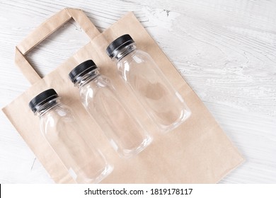 Mockup, Scene Creator. Paper Bag, Three Plastic Bottles. Eco-friendly Food Packaging And Cotton Eco Bags On Gray Background With Copy Space. Containers For Catering And Street Fast Food