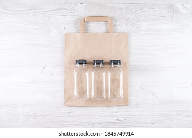 Mockup, Scene Creator. Paper Bag, Three Plastic Bottles. Eco-friendly Food Packaging And Cotton Eco Bags On Gray Background With Copy Space. Containers For Catering And Street Fast Food