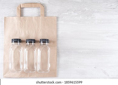 Mockup, Scene Creator. Paper Bag, Three Plastic Bottles. Eco-friendly Food Packaging And Cotton Eco Bags On Gray Background With Copy Space. Containers For Catering And Street Fast Food