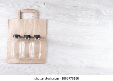 Mockup, Scene Creator. Paper Bag, Three Plastic Bottles. Eco-friendly Food Packaging And Cotton Eco Bags On Gray Background With Copy Space. Containers For Catering And Street Fast Food