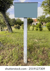 mockup, side view blank or empty notice board on garden or yard of village house in rural area with copy space. blank sign or copy space display at garden of private house. real estate sign for sale