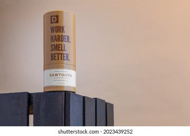 A Mock-up Of A Single Brown Bottle Of Men's Cologne Inside Its Brand Packaging. Product Is Photographed On A Brown Background. Landscape Oriented View.