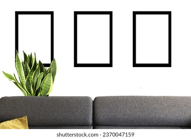 a mockup of a sofa in a living room with a plant in the background with a three black photo frames - Shutterstock ID 2370047159