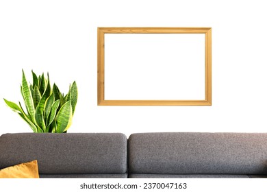 a mockup of a sofa in a living room with a plant in the background with a horizontal wooden frame for photo - Shutterstock ID 2370047163