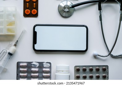 Mockup Space For Text On The IPhone Surrounded By Pills, Seringe With Medicine, Stethoscope On A White Background