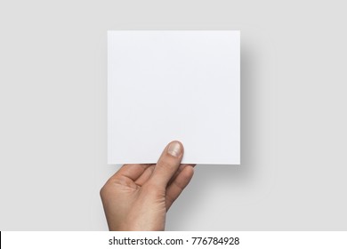 Mockup square empty blank white postcard holds the man in his hand. Isolated on a gray background - Shutterstock ID 776784928