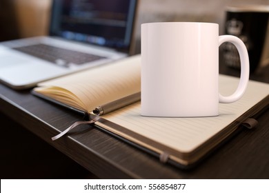 Mockup Styled Stock Product Image, white mug that you can add your custom design/quote to. Mug is on an open notebook next to a laptop. - Shutterstock ID 556854877