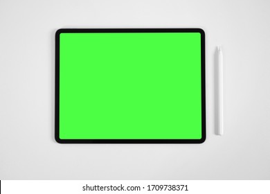 Mockup of tablet and digital pencil with pre-keyed green screen on white table. - Powered by Shutterstock